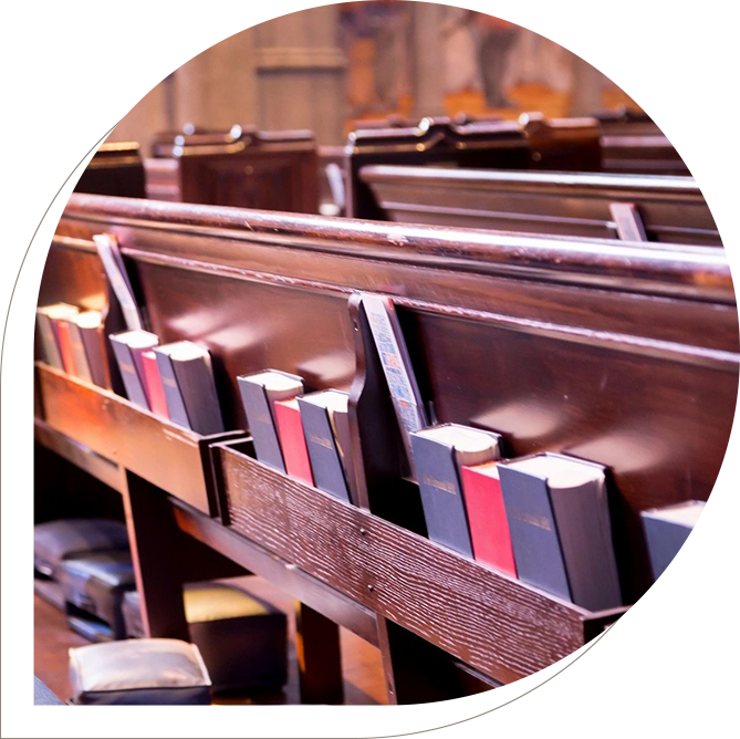 A row of pews with books in them.